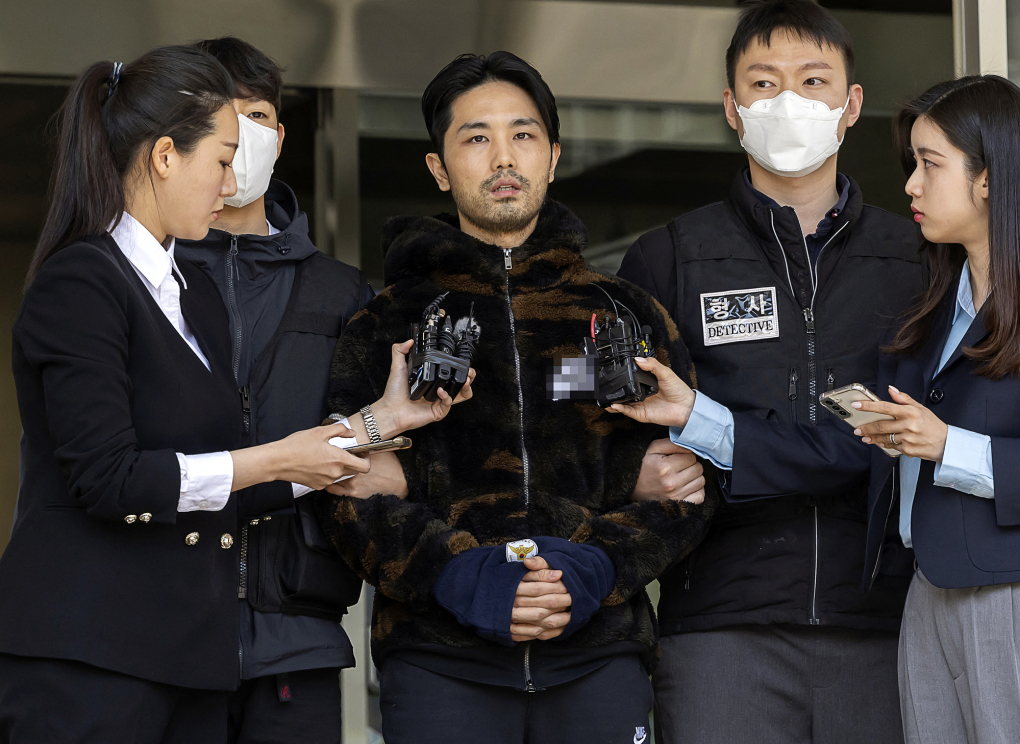 Lee Kyung-woo (giữa), bị áp giải từ đồn cảnh sát tới cơ quan công tố ở Seoul, ngày 9/4. Ảnh: AFP